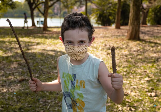 Niño brasileño con máscara en el parque