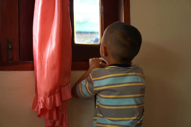 El niño brilla a través de la ventana.