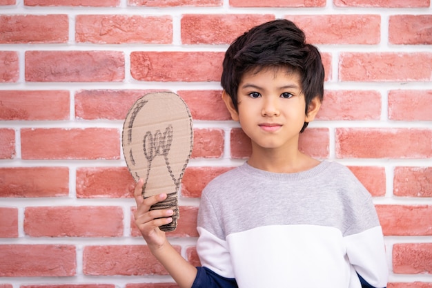 Niño con bulbo de papel para el concepto de idea