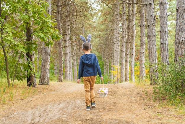 Un niño buscando huevos de Pascua en el bosque