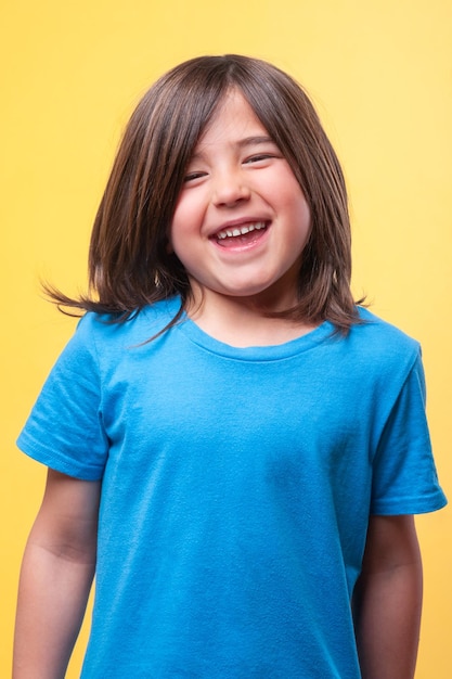 Foto un niño con el cabello marrón está sonriendo y con una camisa azul