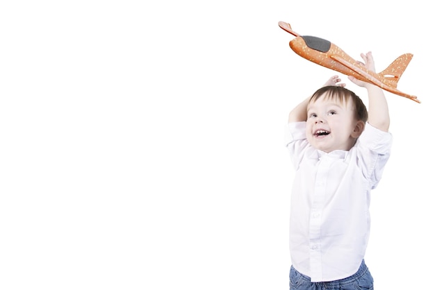 Niño con cabello rubio sonriendo y emociones en la cara y manos levantadas con un avión de dos años Fondo blanco aislado