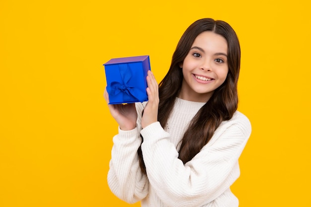 Niño con caja de regalo sobre fondo de estudio aislado Regalos para cumpleaños de niños Cara feliz emociones positivas y sonrientes de niña adolescente