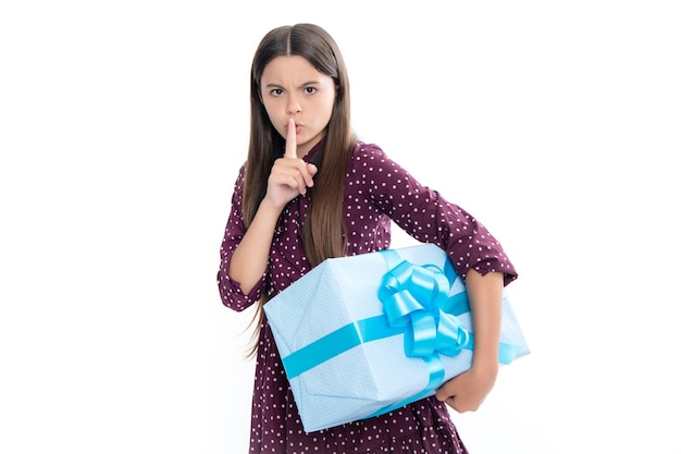 Foto niño con caja de regalo sobre fondo de estudio aislado regalos para cumpleaños de niños chica adolescente seria shhh secreto