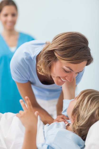 Niño en una cama médica mirando a su madre