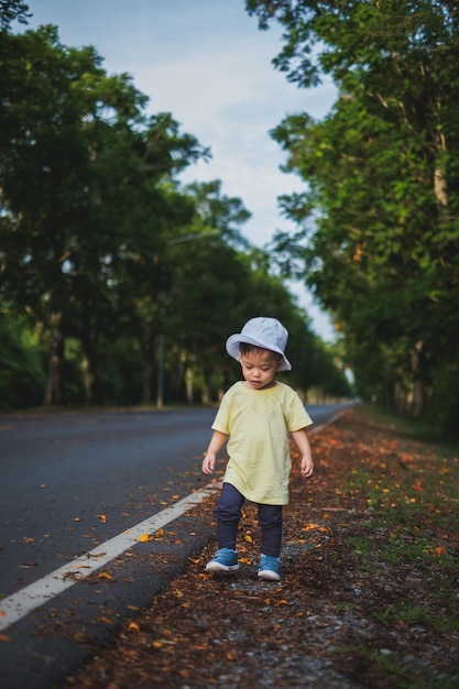 Foto un niño camina en un parque de otoño rodeado de naturaleza