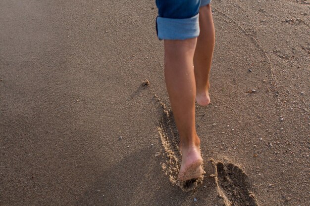 Niño camina por la playa de arena del mar