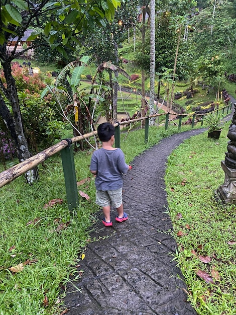 Un niño camina por un sendero en un parque.