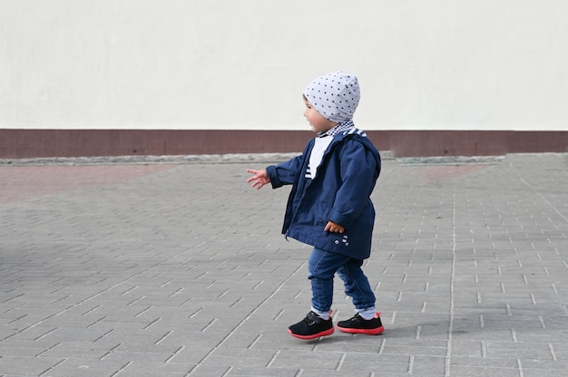 Niño camina sobre un azulejo de la calle. lugar para inscripción