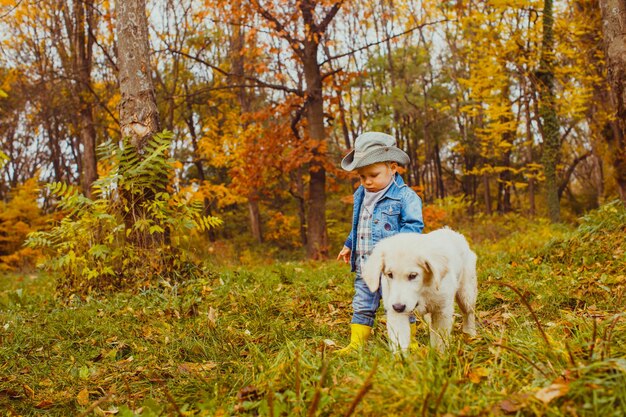 niño caminando con un cachorro golden retriever en el parque