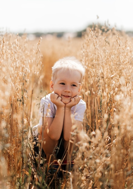 Niño caminando por el campo en verano. Infancia. Hora de verano. Vacaciones de verano