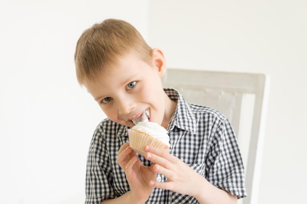 Un niño con una camisa come un pastel sobre un fondo claro La alegría de los dulces