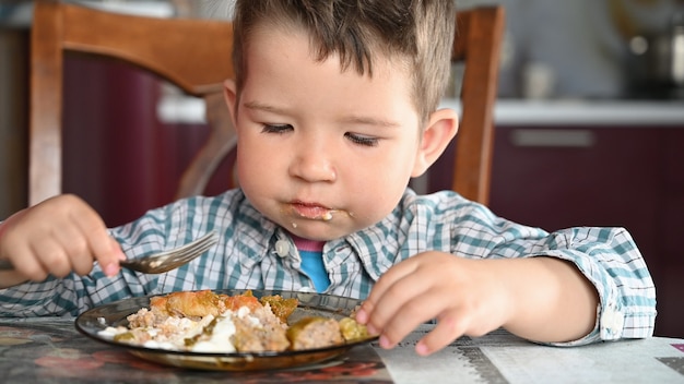 Foto niño en camisa comiendo de cerca.