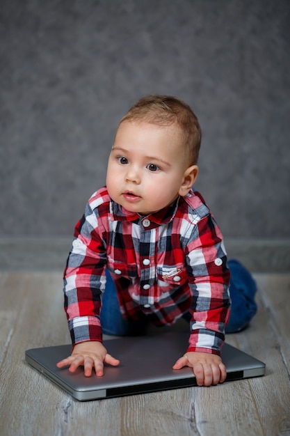 Niño en camisa juega con el portátil