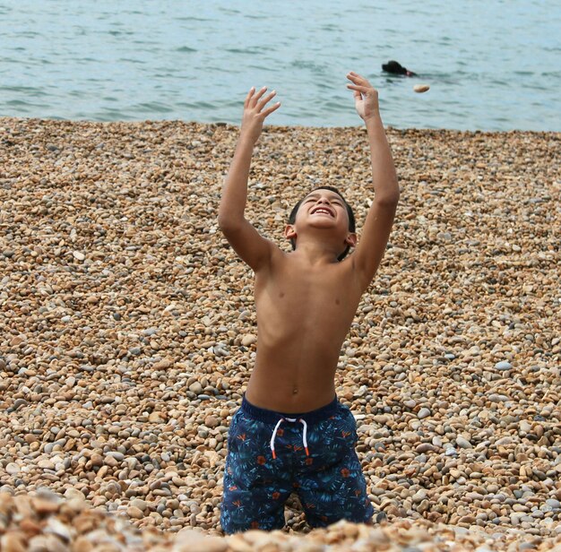 Foto niño sin camisa jugando en la playa