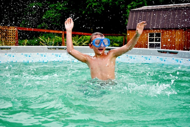 Niño sin camisa nadando en la piscina