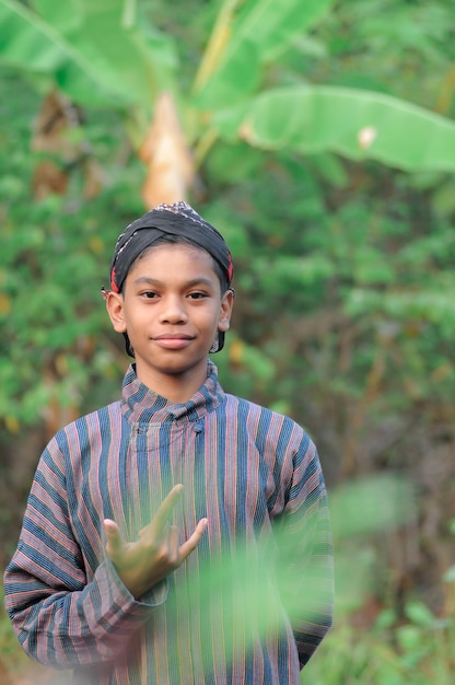 Un niño con una camisa a rayas y una bandana negra
