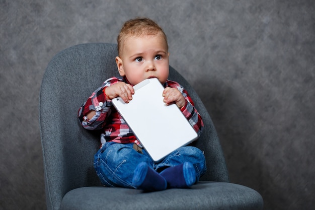 Un niño con una camisa roe una tableta