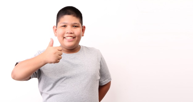 Foto niño en camiseta mostrando gesto ok sobre fondo blanco.