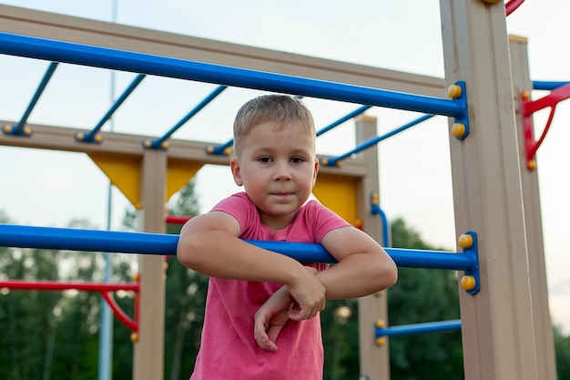 Un niño con una camiseta roja en el patio de recreo.