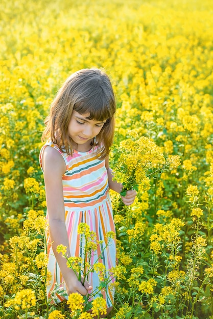 Un niño en un campo amarillo, flores de mostaza