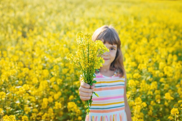 Un niño en un campo amarillo, flores de mostaza