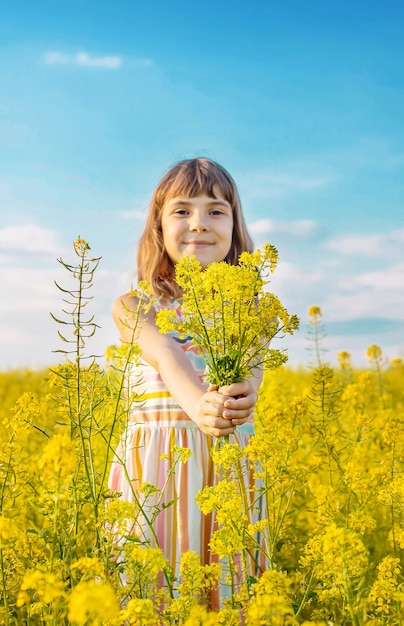 Un niño en un campo amarillo, flores de mostaza.