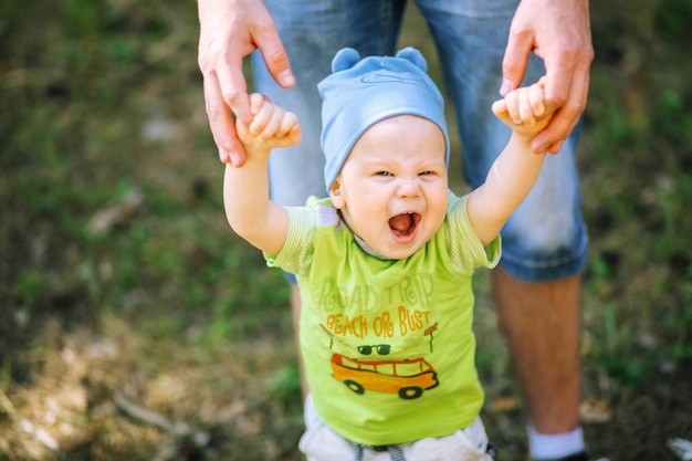 niño en un campo de flores Vida en el campo Vacaciones familiares El niño está sosteniendo la mano de su papá