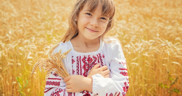 Un niño en un campo de trigo con una camisa bordada. Ucranio.