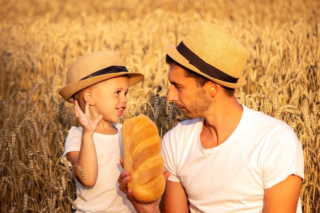 Un niño en un campo de trigo come pan. Naturaleza. enfoque selectivo