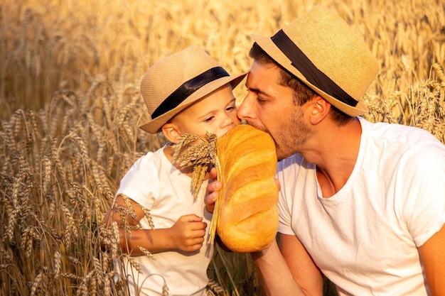 Un niño en un campo de trigo come pan. Naturaleza. enfoque selectivo