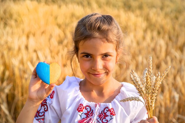 Niño en un campo de trigo En vyshyvanka el concepto del Día de la Independencia de Ucrania Enfoque selectivo