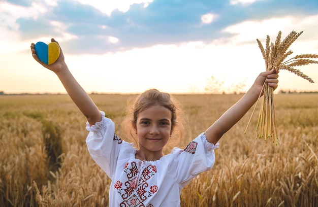 Foto niño en un campo de trigo en vyshyvanka el concepto del día de la independencia de ucrania enfoque selectivo