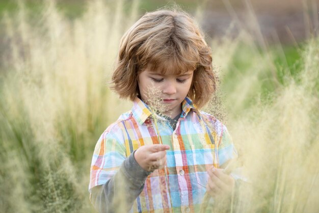 Niño en el campo de verano Paseo al aire libre Primer plano lindo niño rubio Niño emociones concepto Retrato de joven niño sonriente fuera