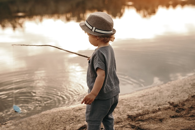 Niño con caña de pescar en el lago