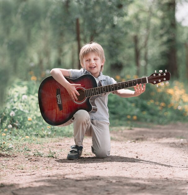 Niño canta una canción en el camino del parque. el concepto de una infancia feliz