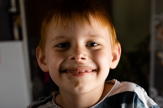 Un niño con la cara de helado sucia.