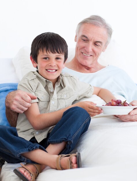 Niño cariñoso cuidando a su abuelo