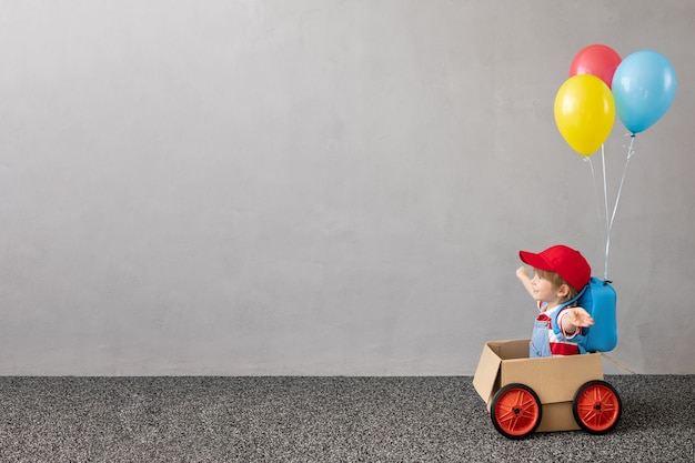 Niño en carro de cartón. Niño divirtiéndose en casa.