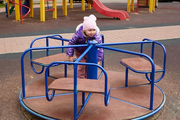 Niño en un carrusel en el patio de recreo