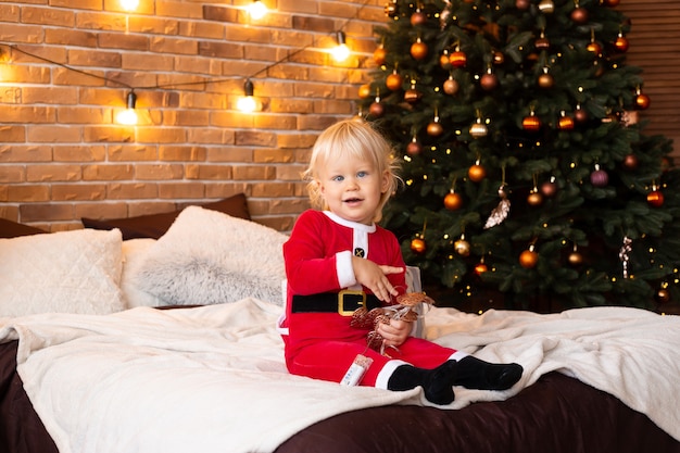 Niño en casa cerca del árbol de Navidad. Concepto de temporadas de año nuevo, invierno y vacaciones.