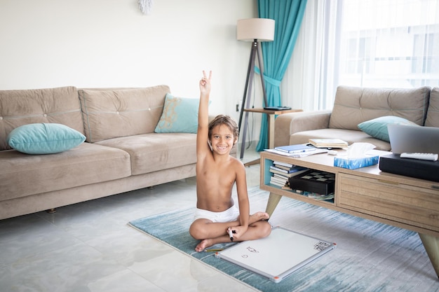 Niño en casa sentado y dibujando a bordo