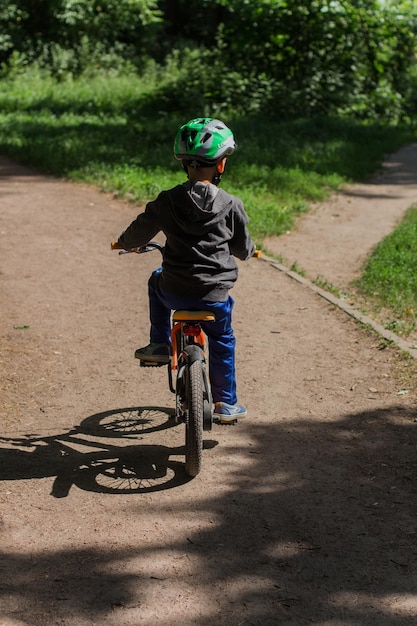 Niño con casco en bicicleta en el parque