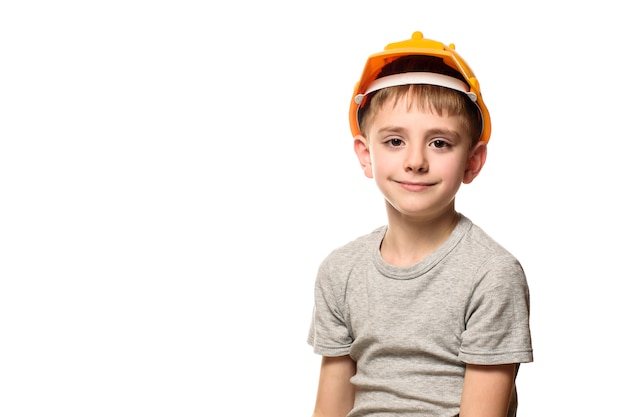 Niño en casco de construcción naranja. Retrato. Aislar sobre fondo blanco