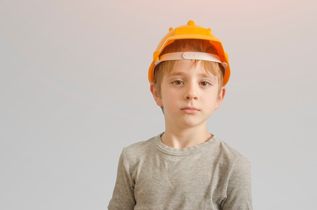 Niño en el casco del constructor y gafas. Aislar