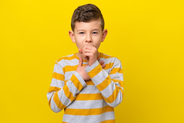 Un niño caucásico aislado de fondo amarillo tosiendo mucho