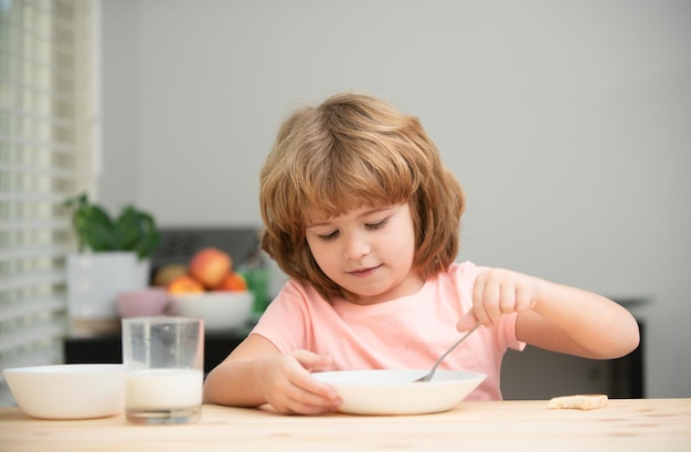 Niño caucásico comiendo sopa saludable en la cocina rostro en primer plano de un niño lindo