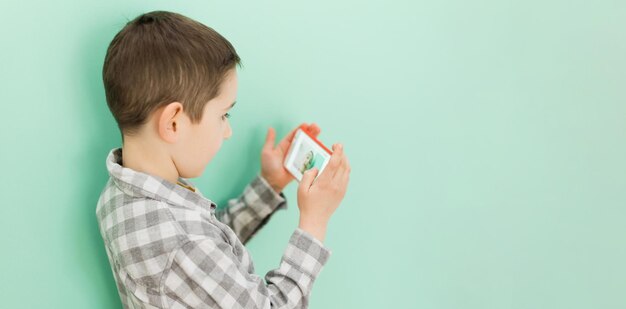 Foto niño caucásico con espacio de copia de teléfono inteligente