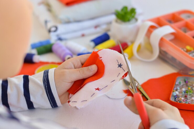 Foto un niño caucásico está aprendiendo a coser con sus manos un regalo casero para mamá para unas vacaciones