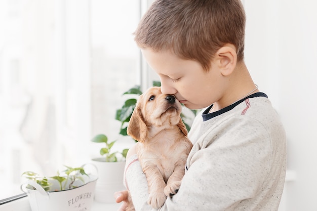 Foto niño caucásico, tenencia, cocker spaniel inglés, perrito